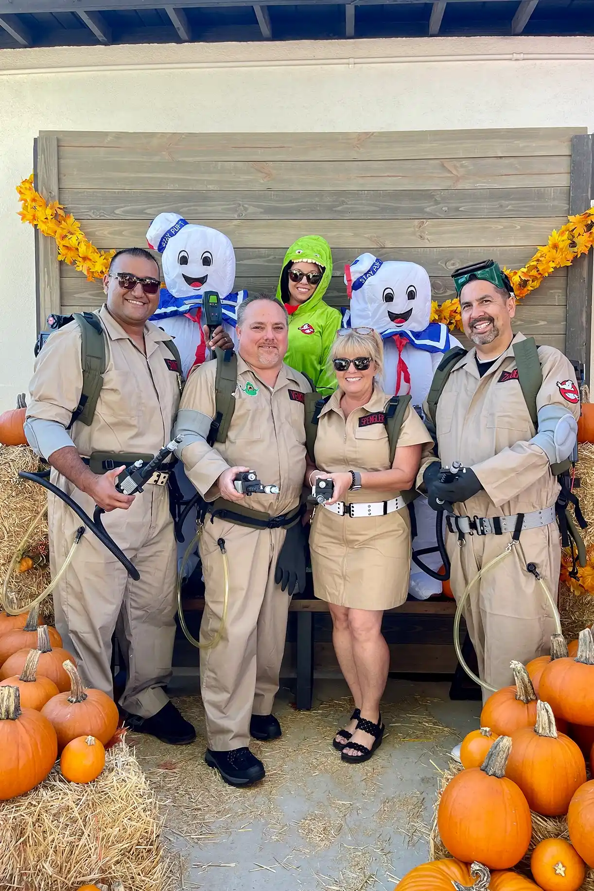 Ghostbusters team poses with Stay Puft marshmallow mascots among pumpkins