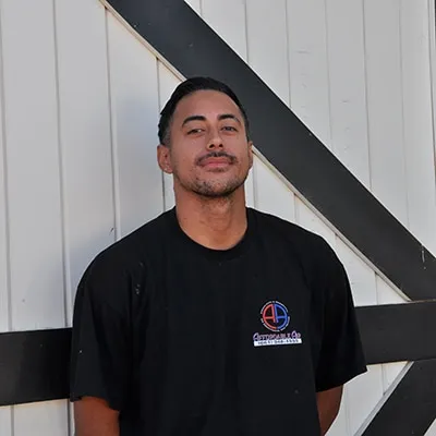 Person in black t-shirt standing against white wall with diagonal lines