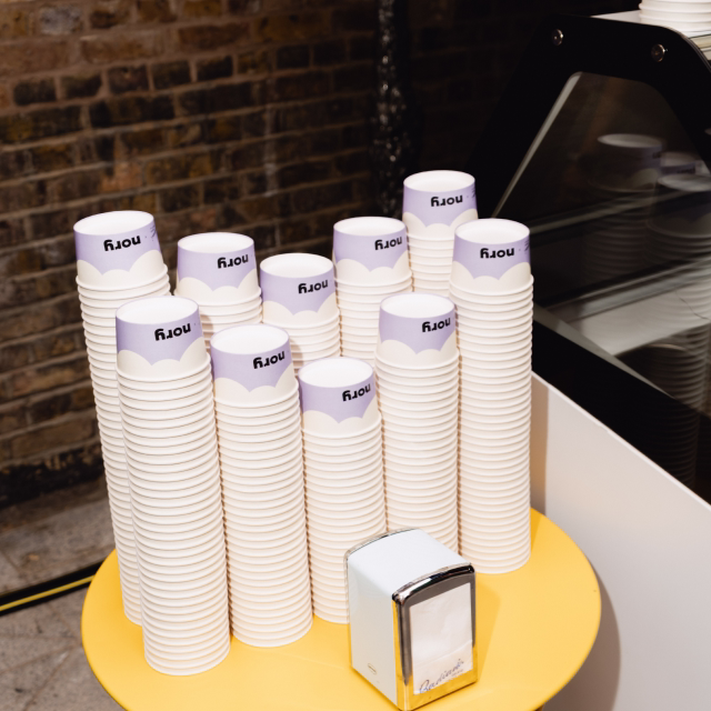 Stacks of Nory branded cups in the office kitchen