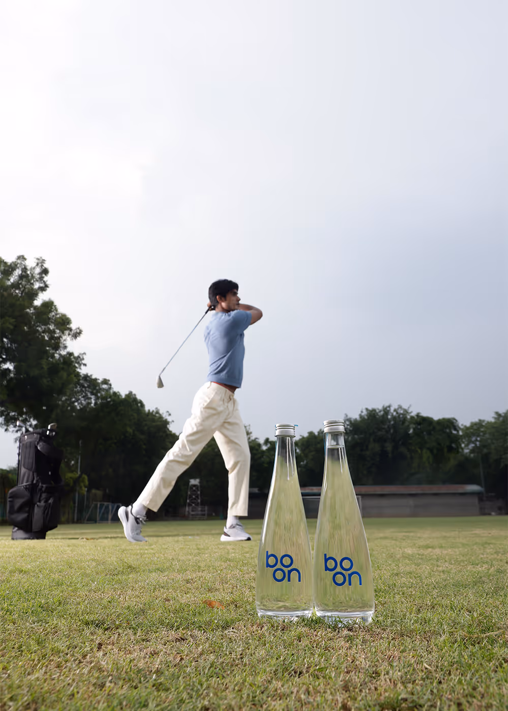 Two bottles of boon with a golf player in the background
