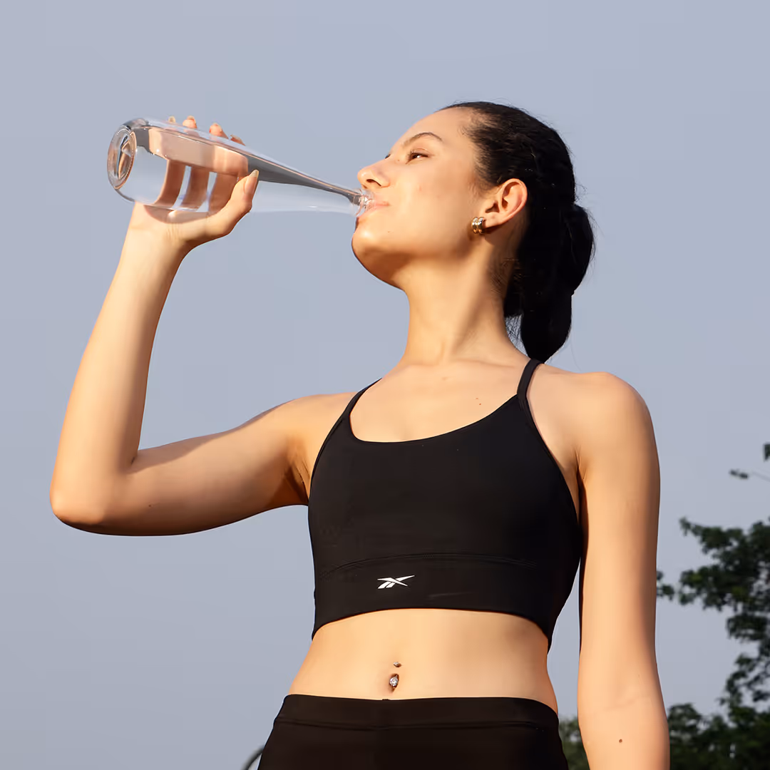 A lady in drinking boon after a workout