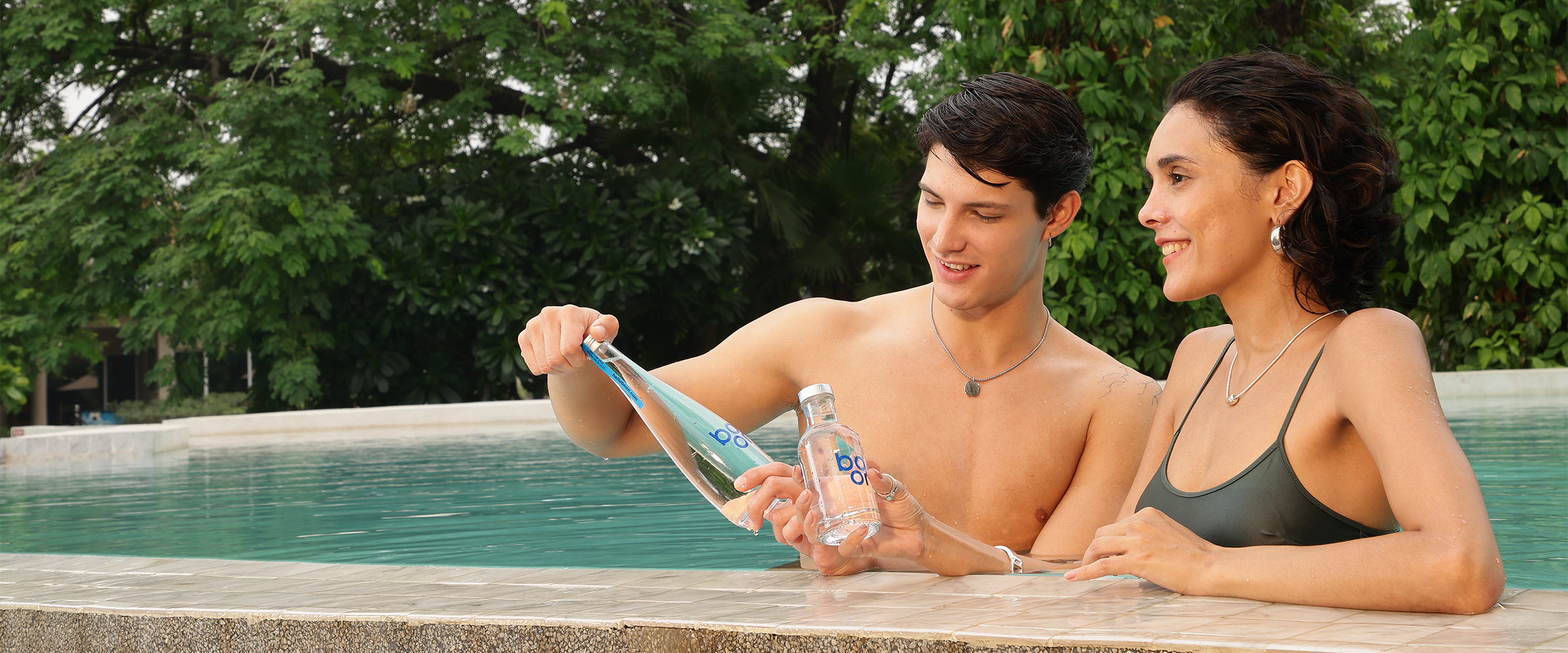 A couple in a swimming pool with boon water bottles