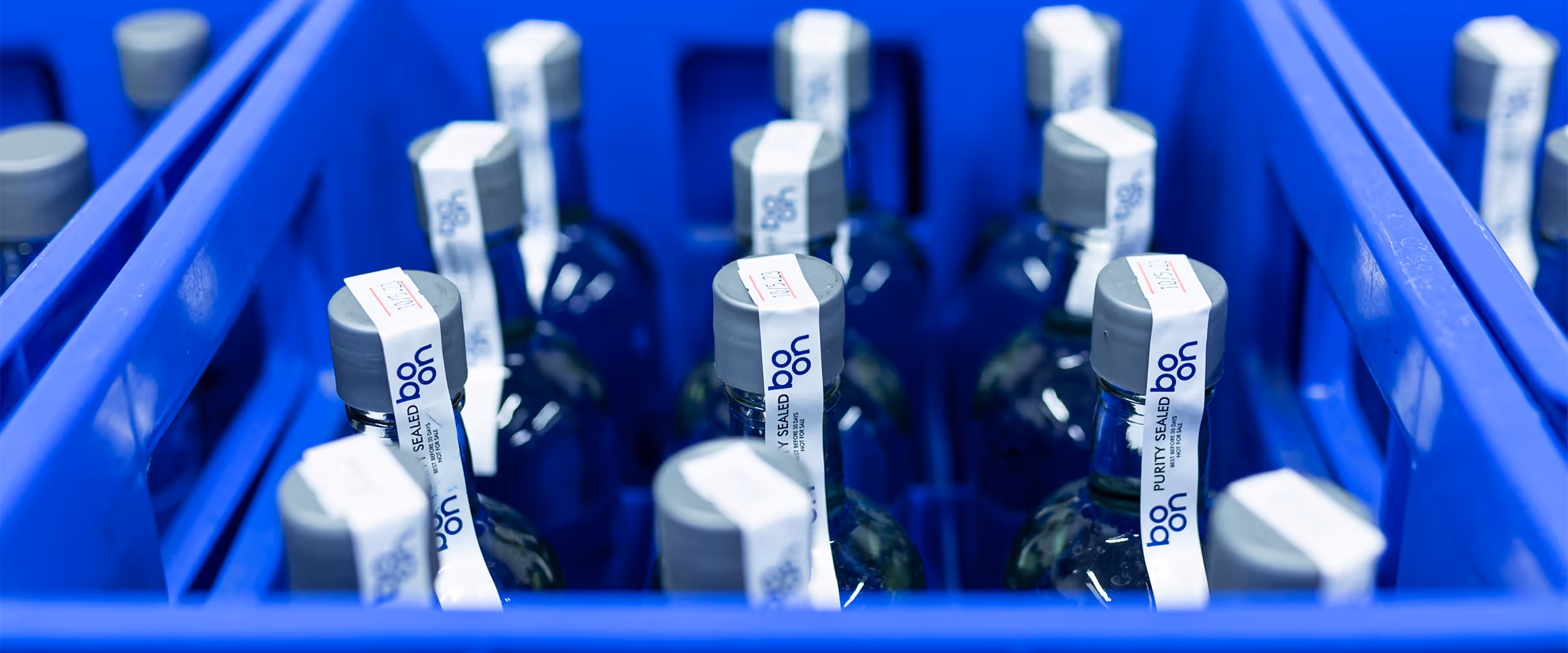 Boon water bottles in blue crates