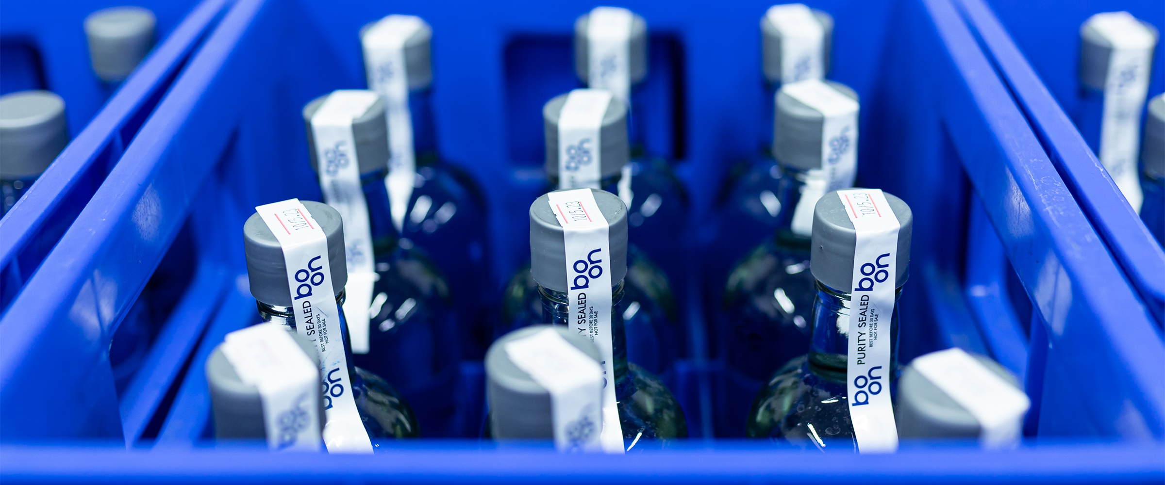 Boon water bottles in blue crates