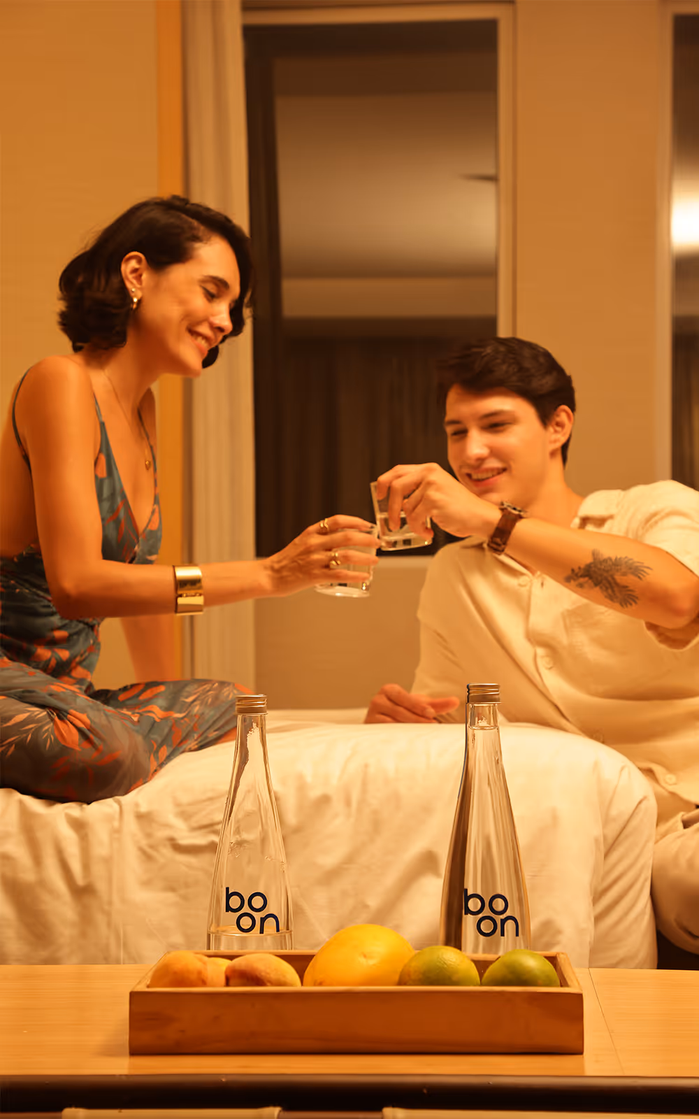 A couple in a hotel room drinking boon water