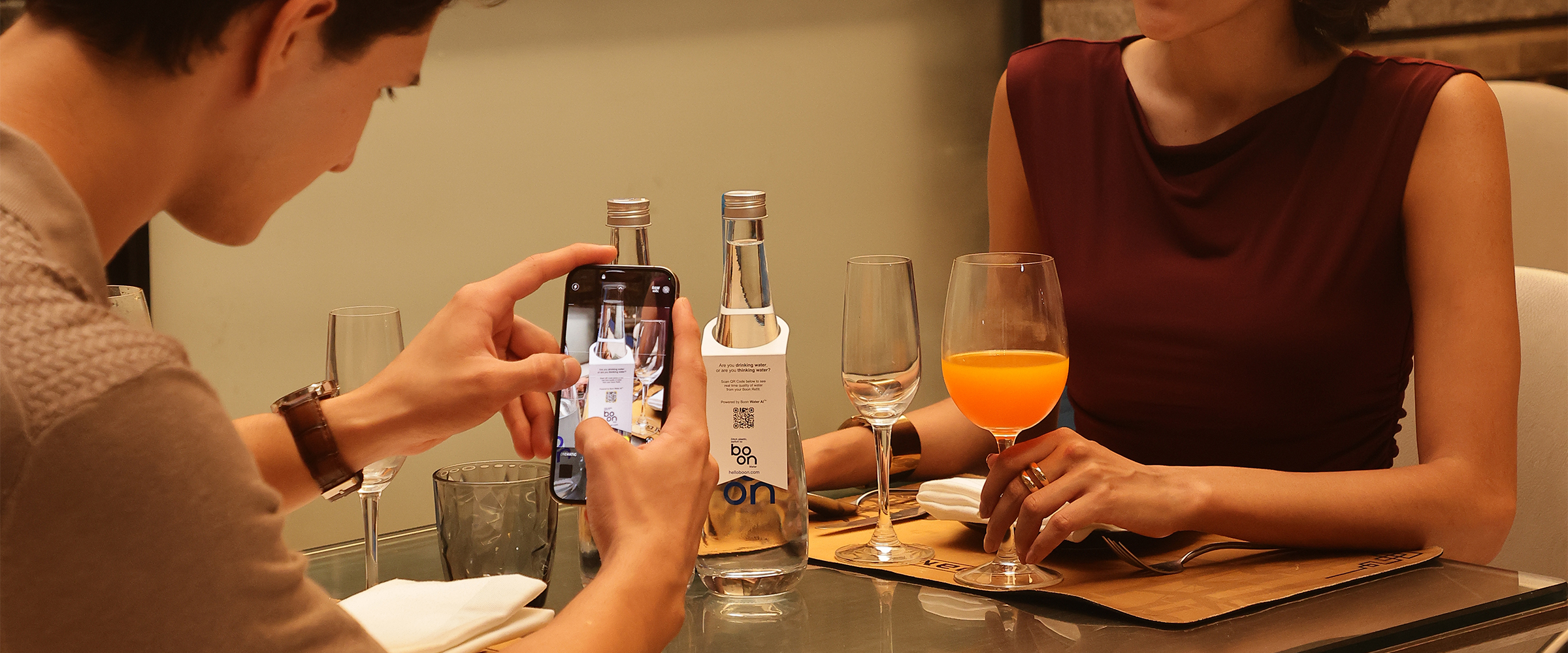 A couple in a restaurant with boon water bottles on the table
