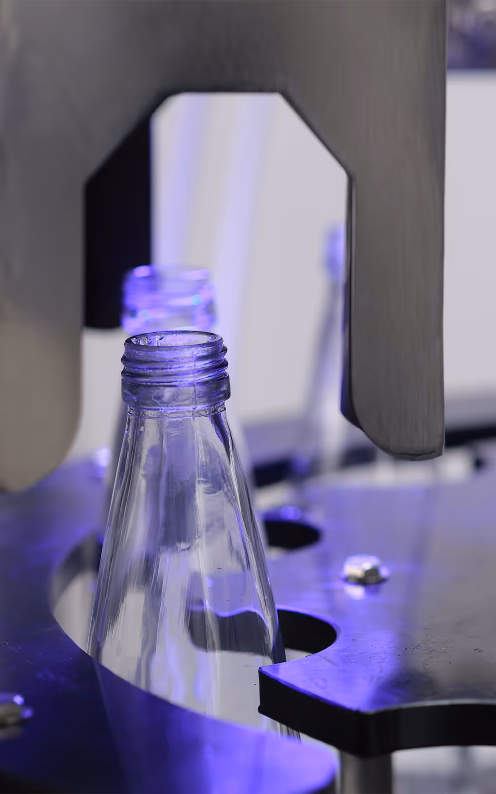 A gloved hand holding a bottle of boon 