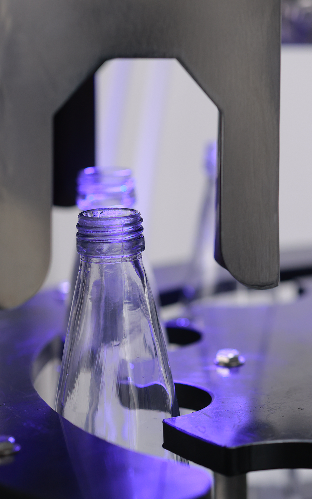 A gloved hand holding a bottle of boon
