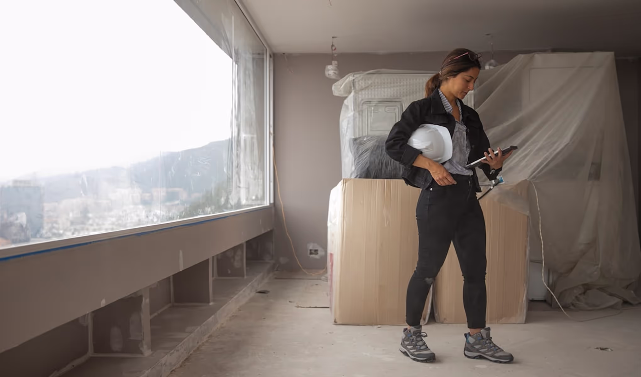 A woman standing in a room holding a cell phone.