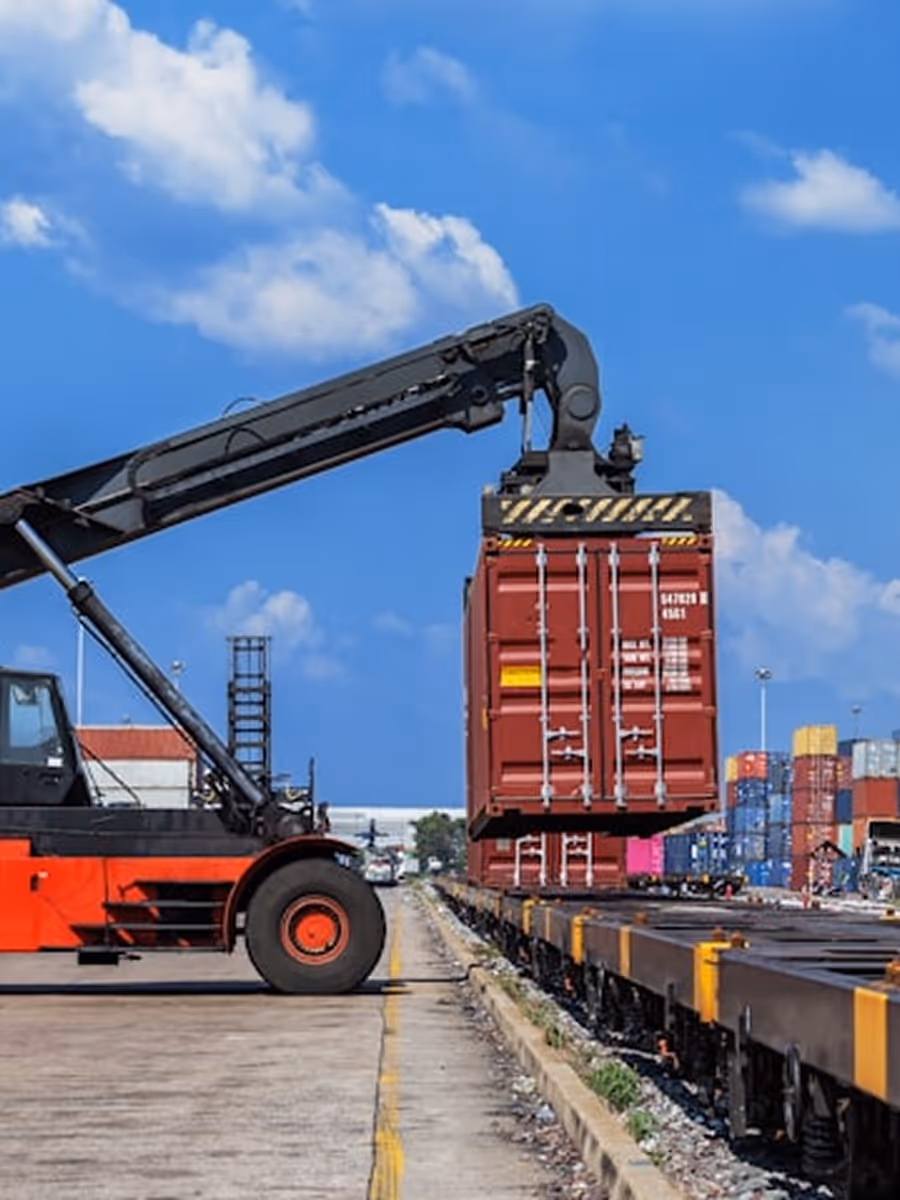 A crane is lifting cargo onto a train.