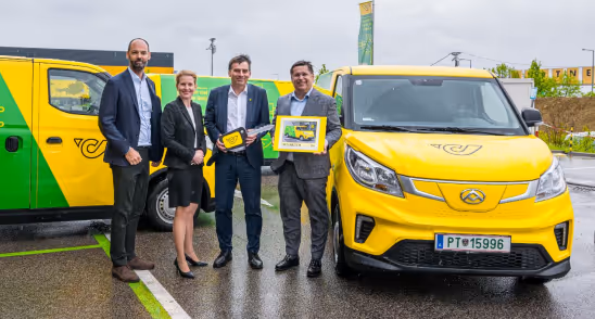 Gruppenfoto MAXUS Motors Österreich und Österreichische Post AG neben gelben Post-Autos der MAXUS Flotte.
