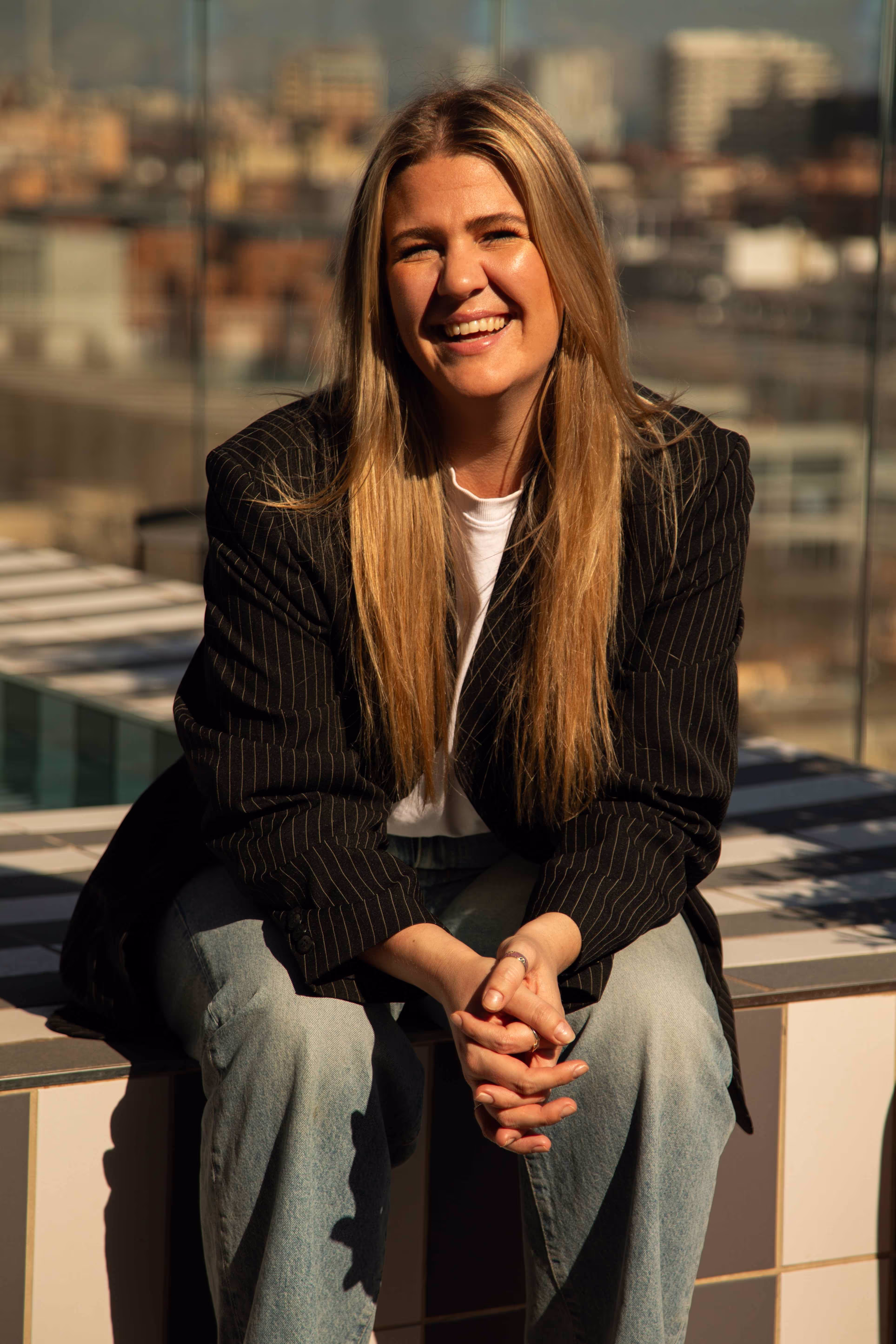 The CEO laughing, wearing a black blazer.