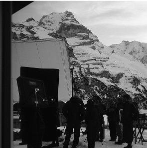 A production crew on a photography set working with Alps in the background