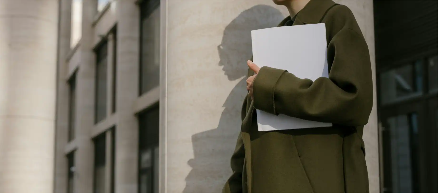 photo d'une personne portant un dossier sous la main en sortie de tribunal
