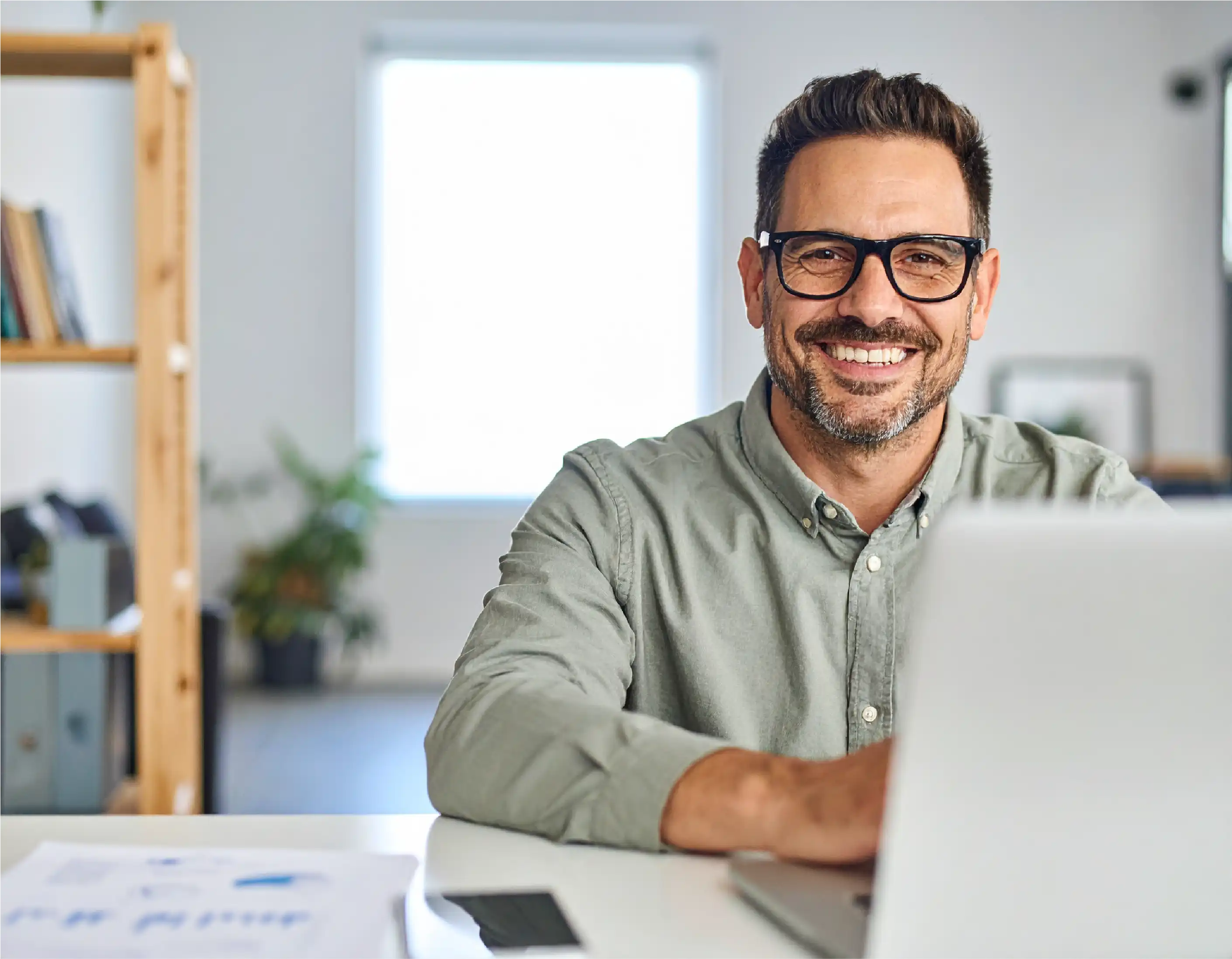 Ingénieur indépendant souriant devant son PC