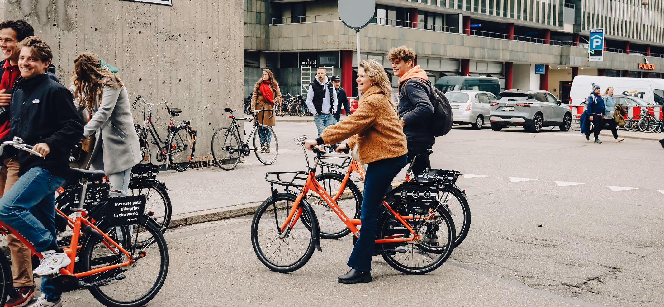 A group of people riding bikes down a street.