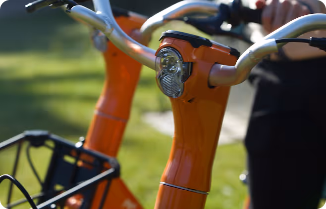 A close up of an orange bike with a basket.