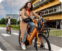 A woman riding a bike down a street.