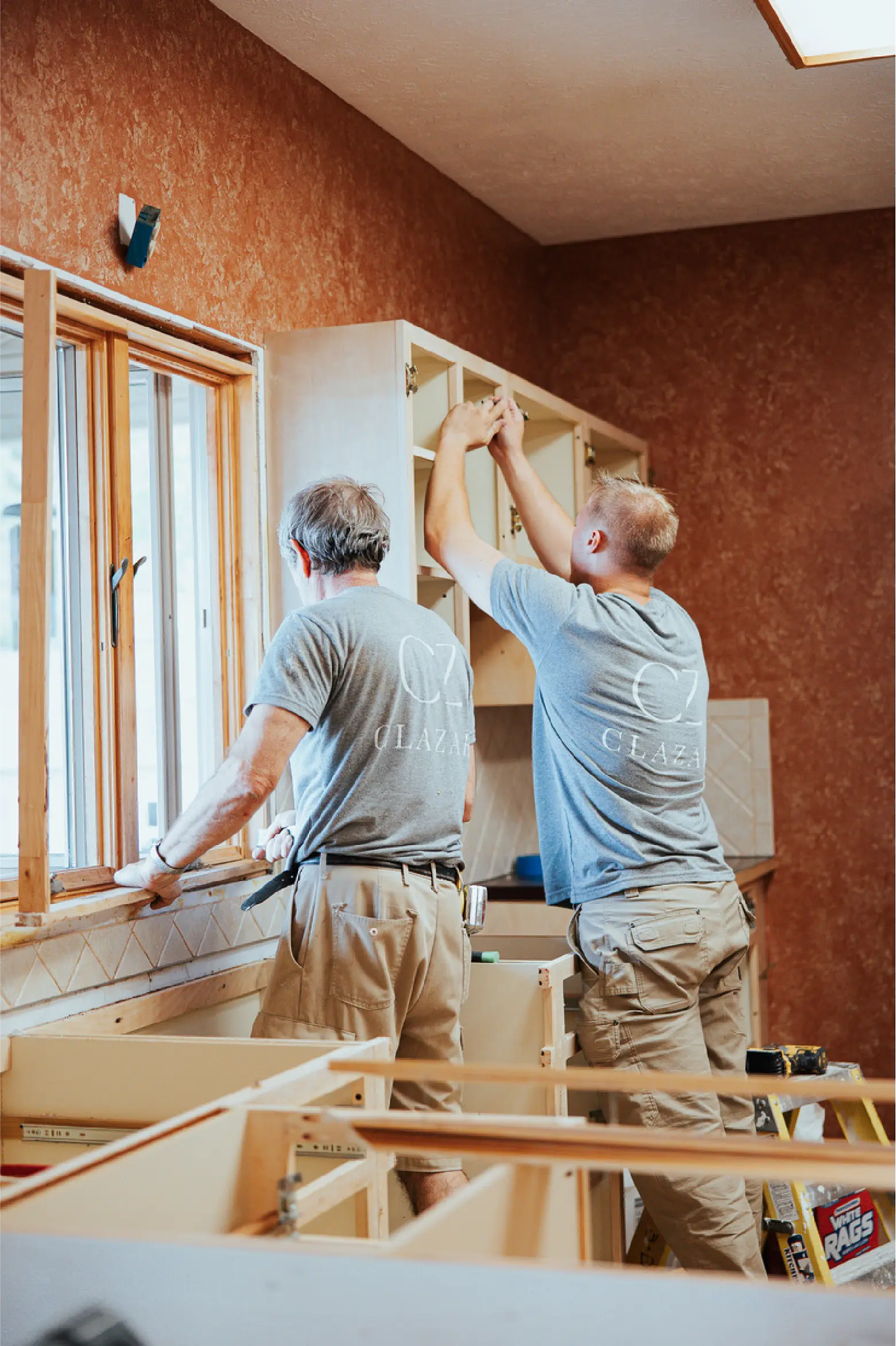 clazak workers installing kitchen cabinets