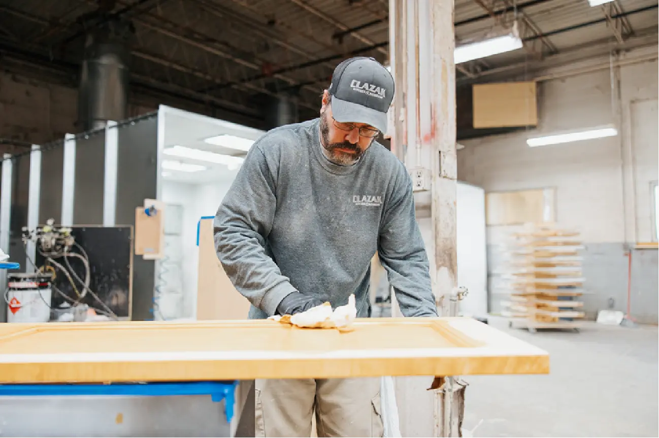 clazak worker wiping board of wood