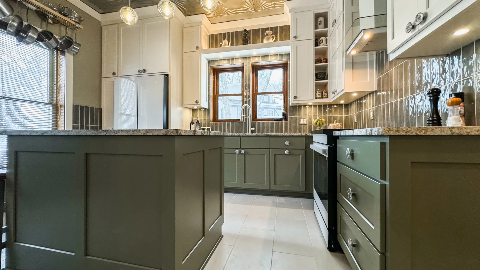 Kitchen with tile backsplash and green and white cabinetry