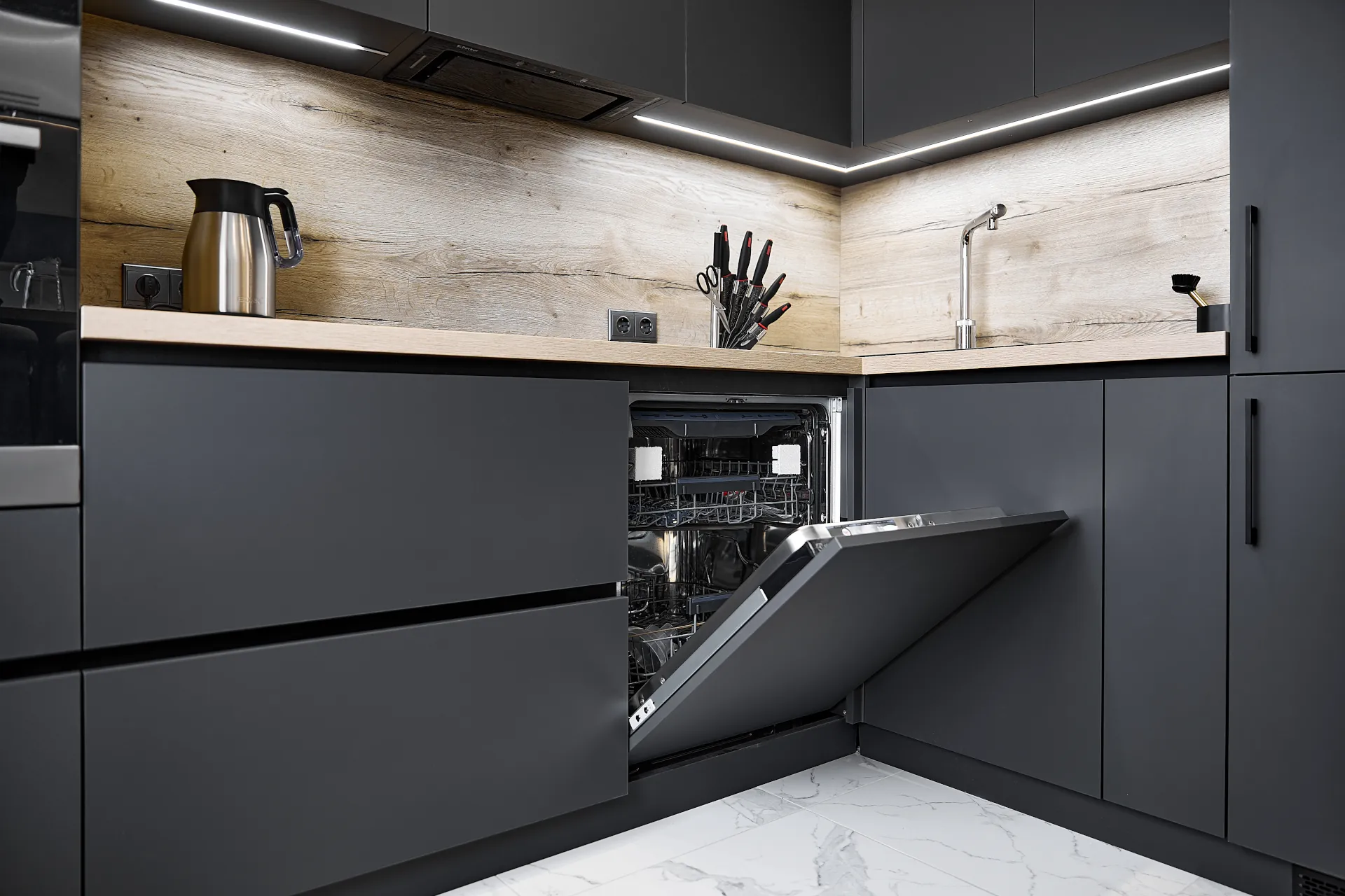 Open dishwasher in black kitchen