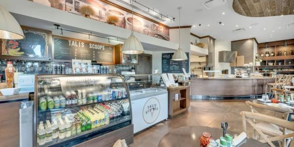 Interior of Talis Scoops ice cream shop with display cases, seating area, and modern decor.