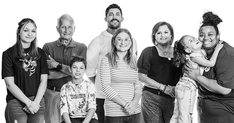 A black & white image of multiple people posing for the photo with happy looks on their faces