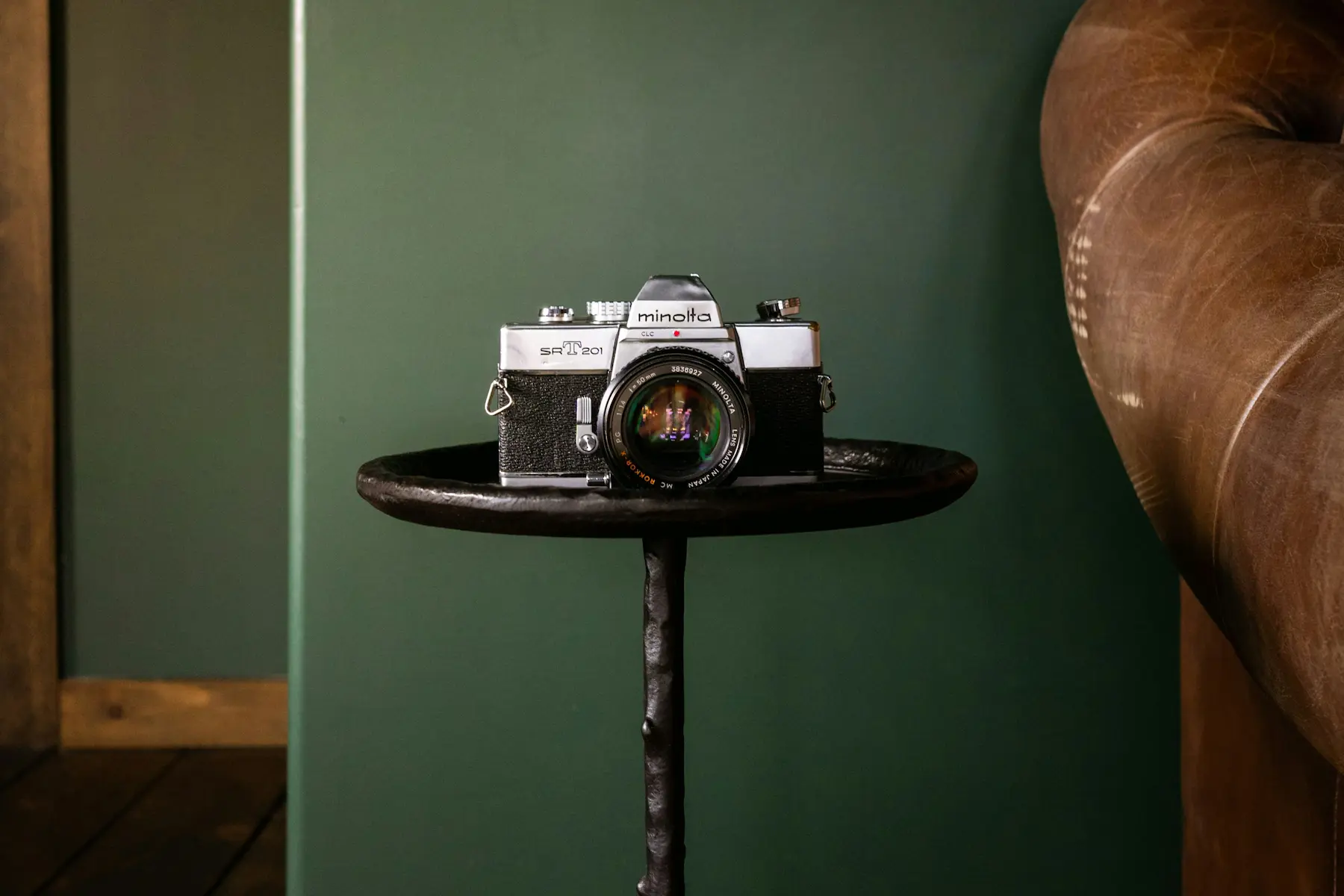 Camera placed on the bedside table at Casa Cribs, adding a touch of travel charm to the elegant bedroom.