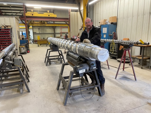 employee next to large feedscrew