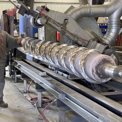 employee next to large feedscrew