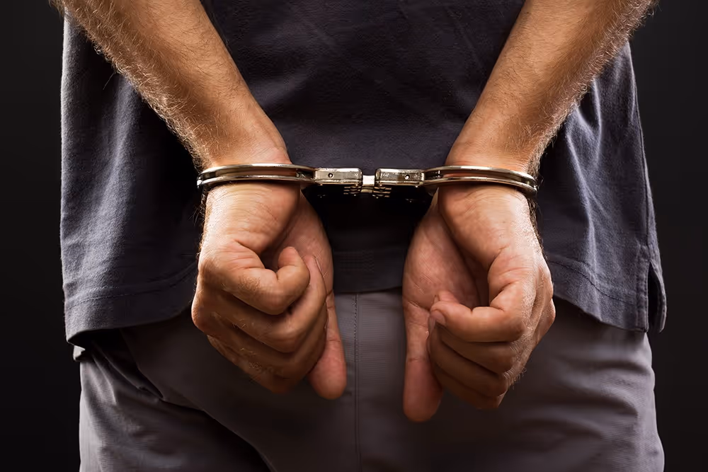 Person in handcuffs representing a fraud investigation by Holborn Adams.