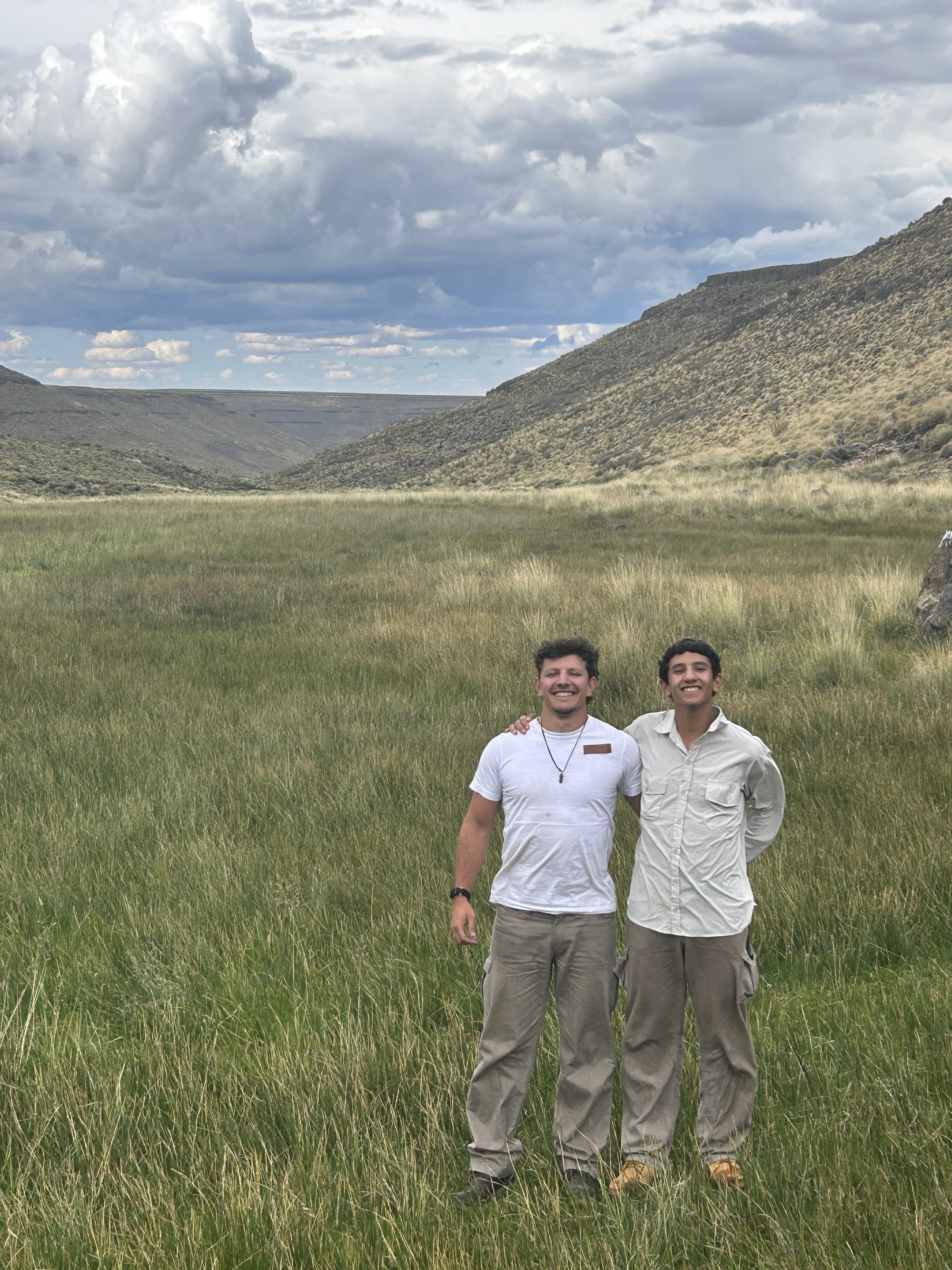 Dos integrantes del equipo en un mallín de pastizal alto