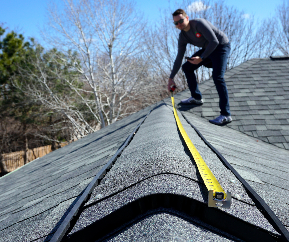 man using a tape measure on roof