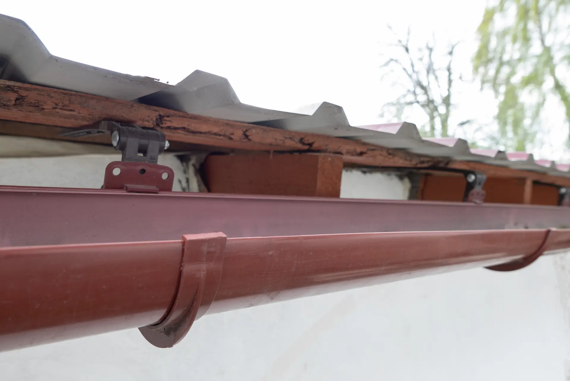 reddish-brown half round gutters on the side of a roof