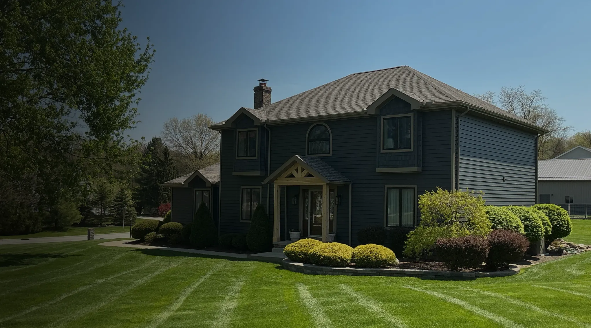 home with shingle roofing with mowed lawn
