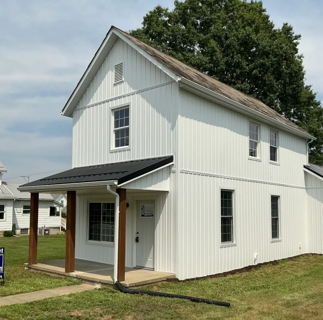 two story home with front porch and awning with metal roof