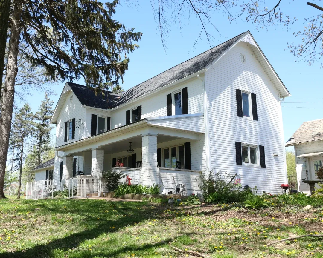white siding home with white brick porch