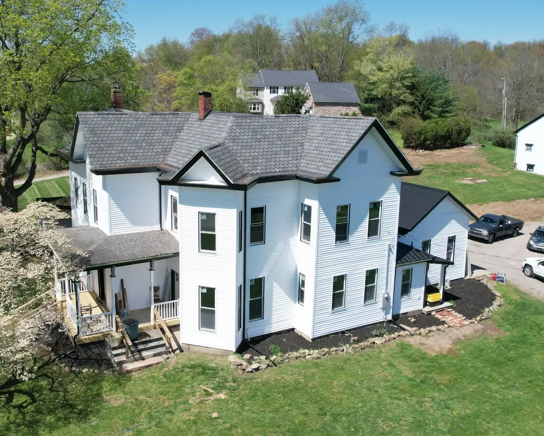 aerial view of two story home with white siding and black trim
