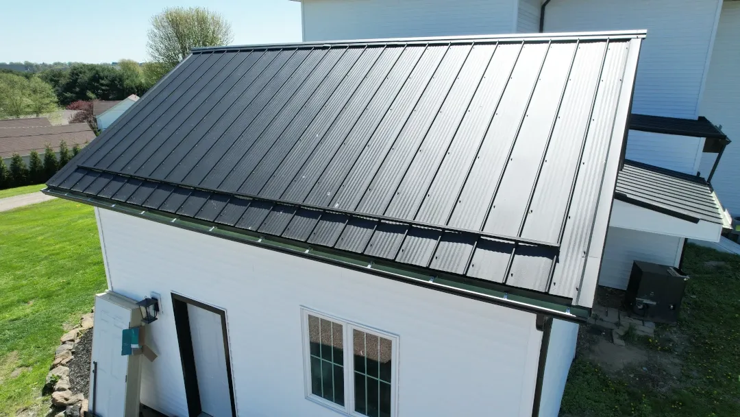 home with new black metal roof and guards