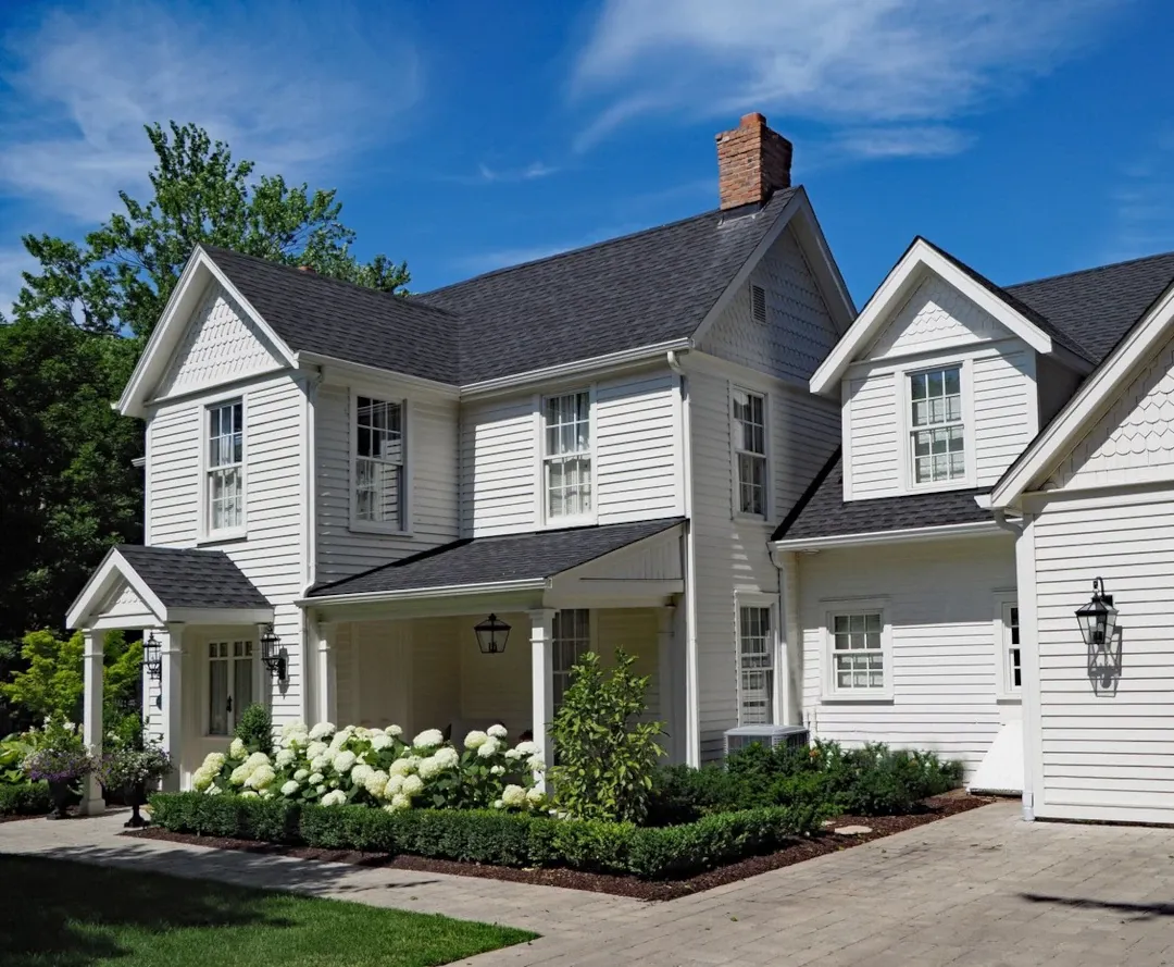 white siding home with chimney and walkway to front door