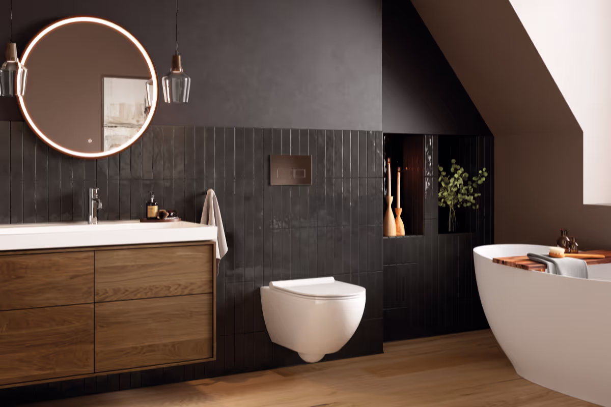 Luxe badkamer met donkere muur. Aan de muur hangt een witte wc en rechts daarvan een los staand bad