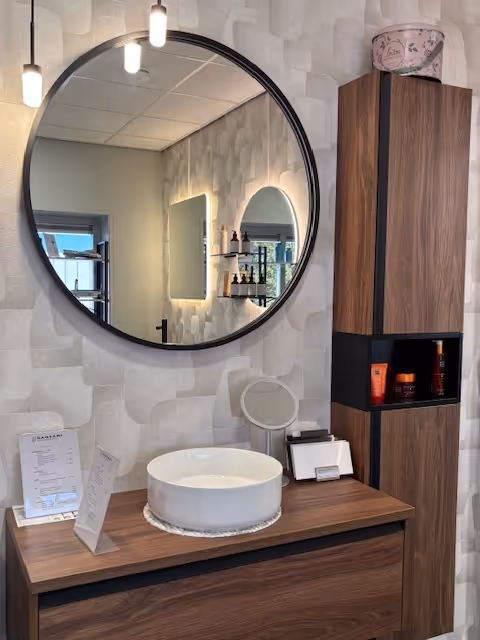 Houten was badkamer meubel met een ronde wasbak en ronde spiegel