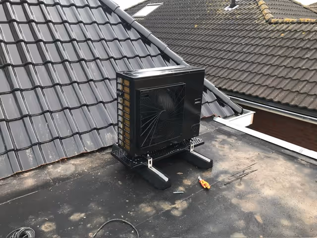 Zwarte warmpe pomp op een plat dak