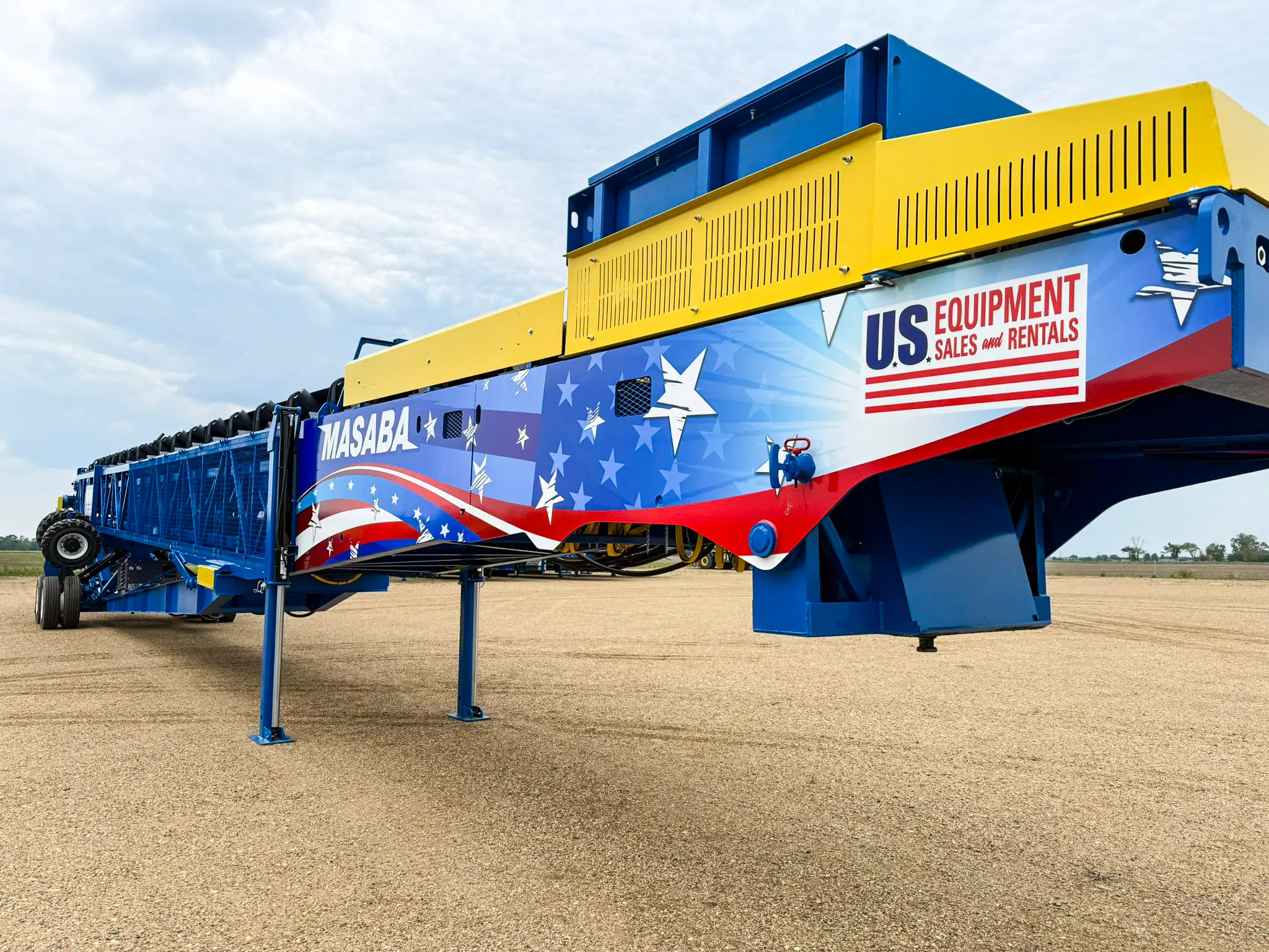 A large, blue and yellow portable screening or conveyor unit branded "US Equipment Sales and Rentals" with Masaba decals, set up on a gravel surface.