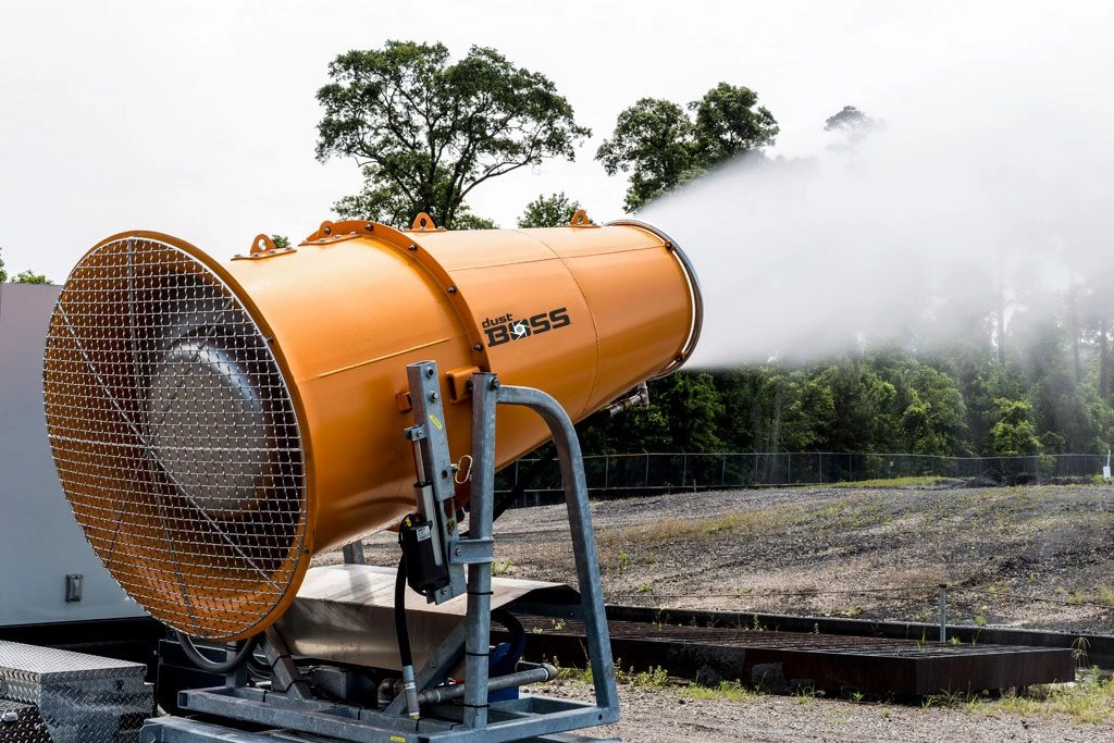 Dust suppression cannon actively spraying mist to control airborne dust at an aggregate and material handling site.