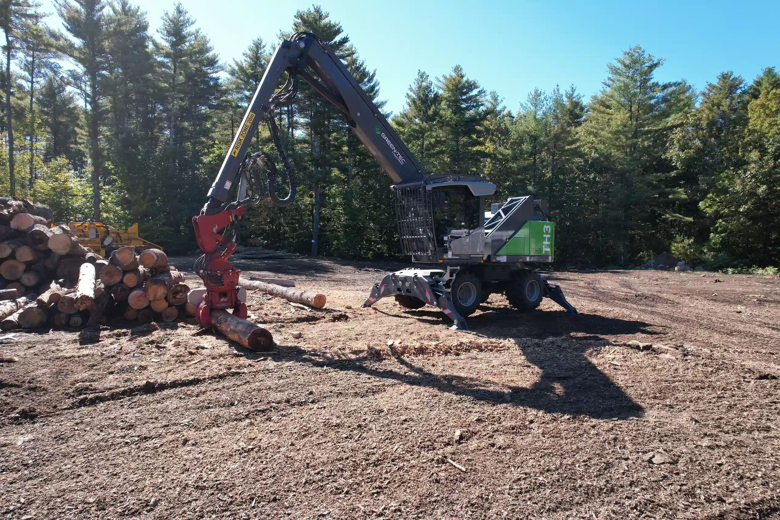 Green-Tec TH3 material handler demonstrated at Timberstock in Newton, showcasing precision log handling for forestry applications.