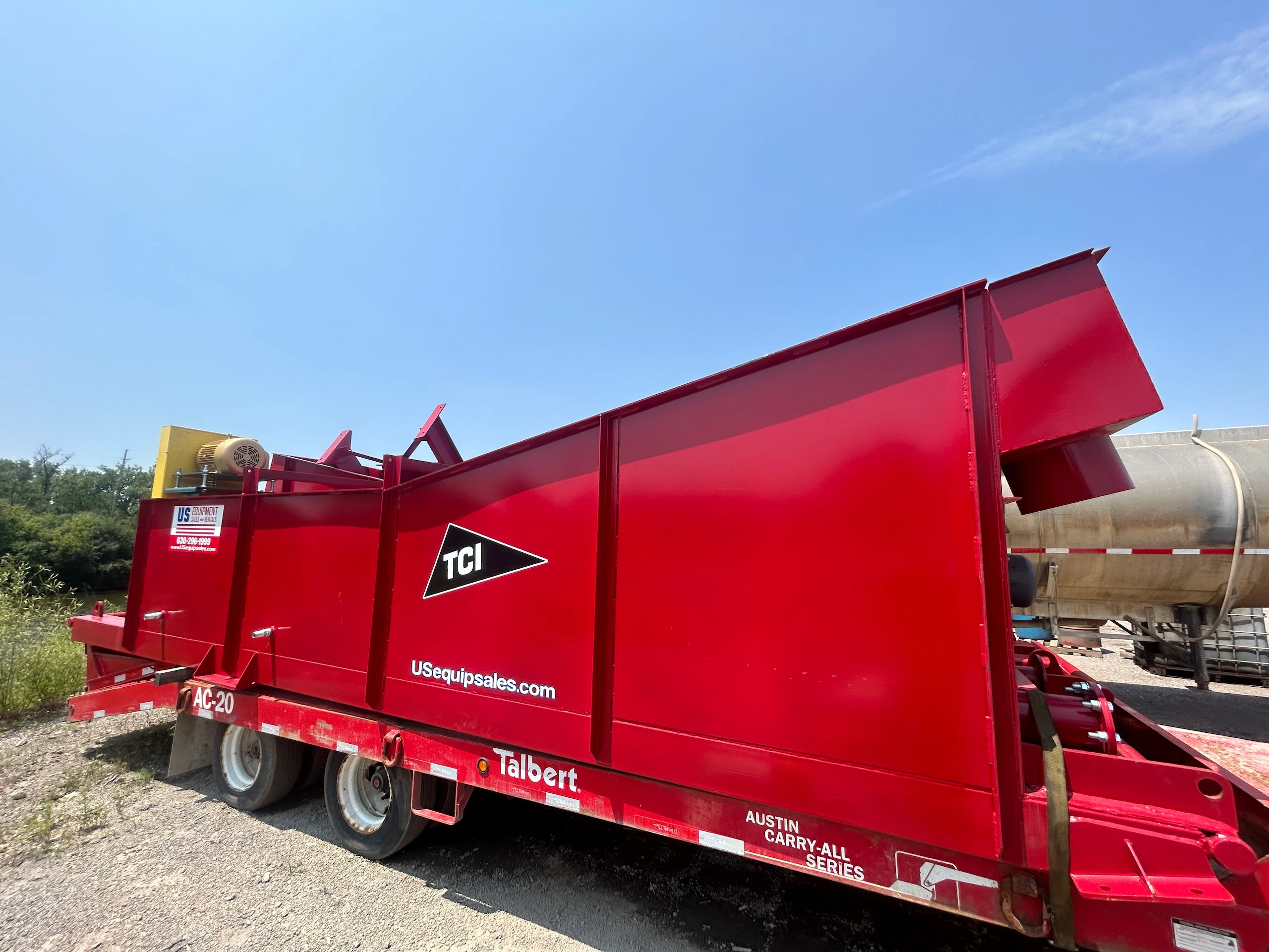 TCI AC-20 portable conveyor mounted on a Talbert Austin Carry-All trailer for efficient material handling.