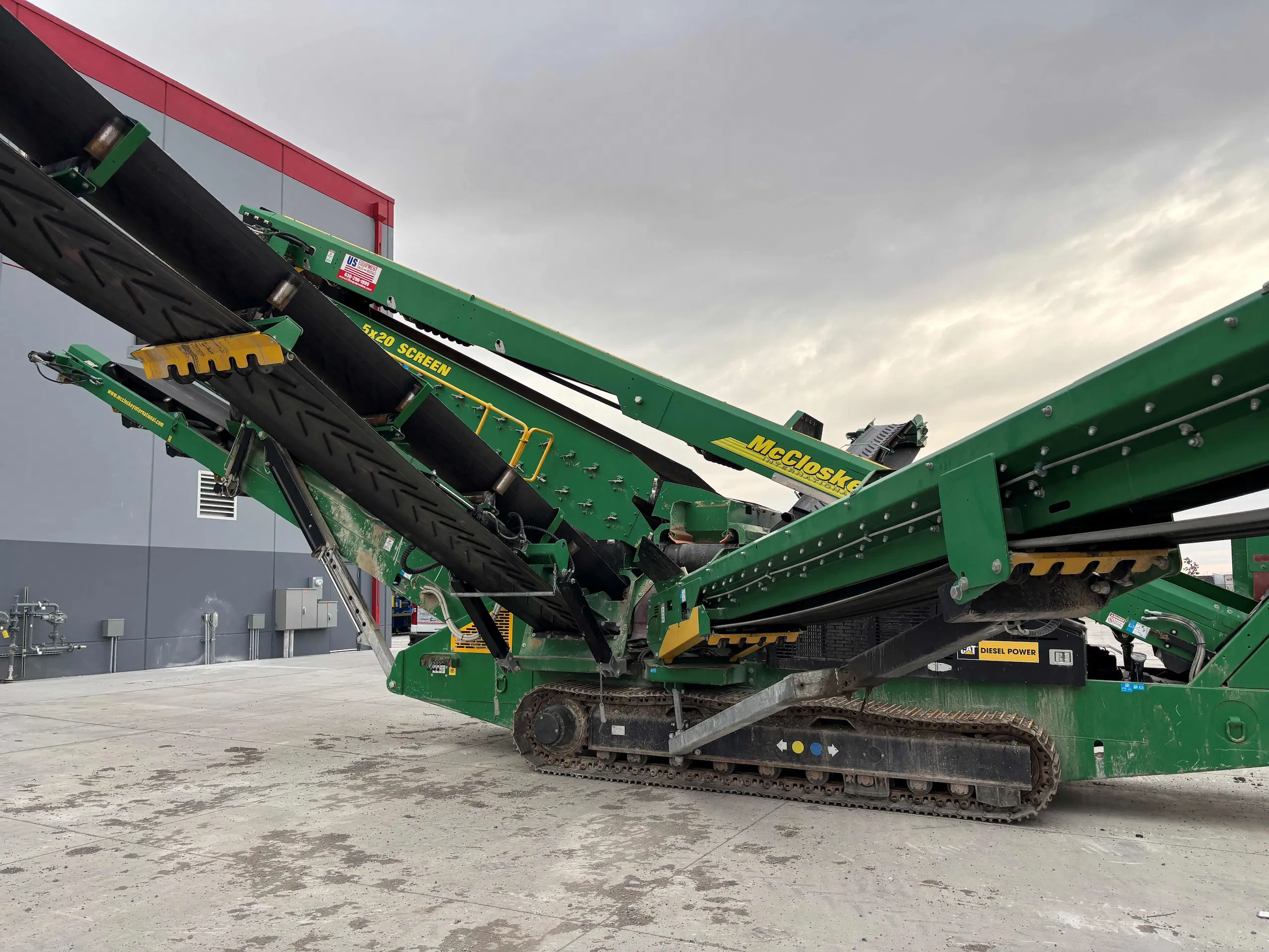 McCloskey mobile screening plant with elevated conveyor discharging processed material at an aggregate site.
