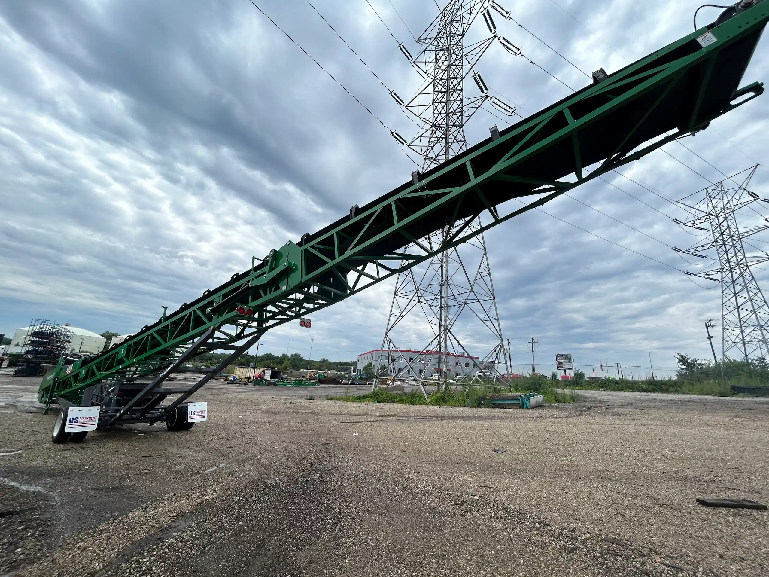 McCloskey ST80 tracked stacker positioned in an equipment yard, showing extended conveyor frame and US Equipment Sales branding.